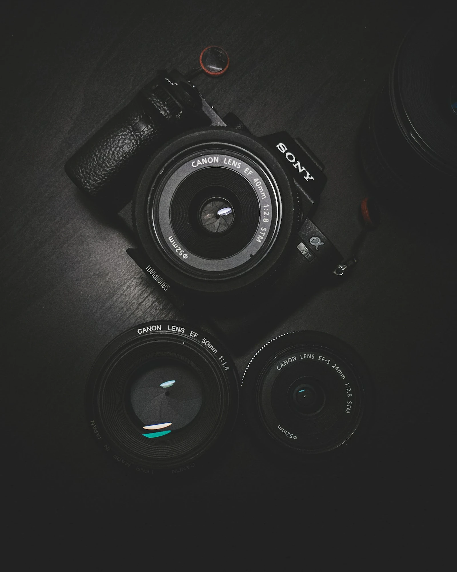 Fotocamera professionale e ottiche su fondo scuro